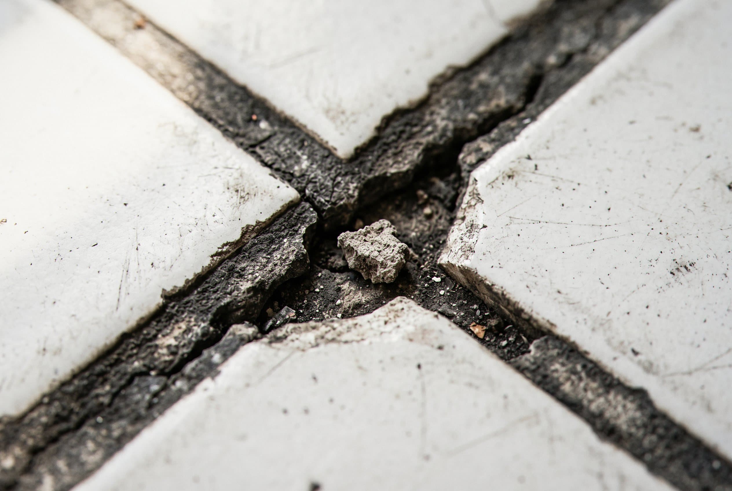 Extreme close-up of cracked white tile grout