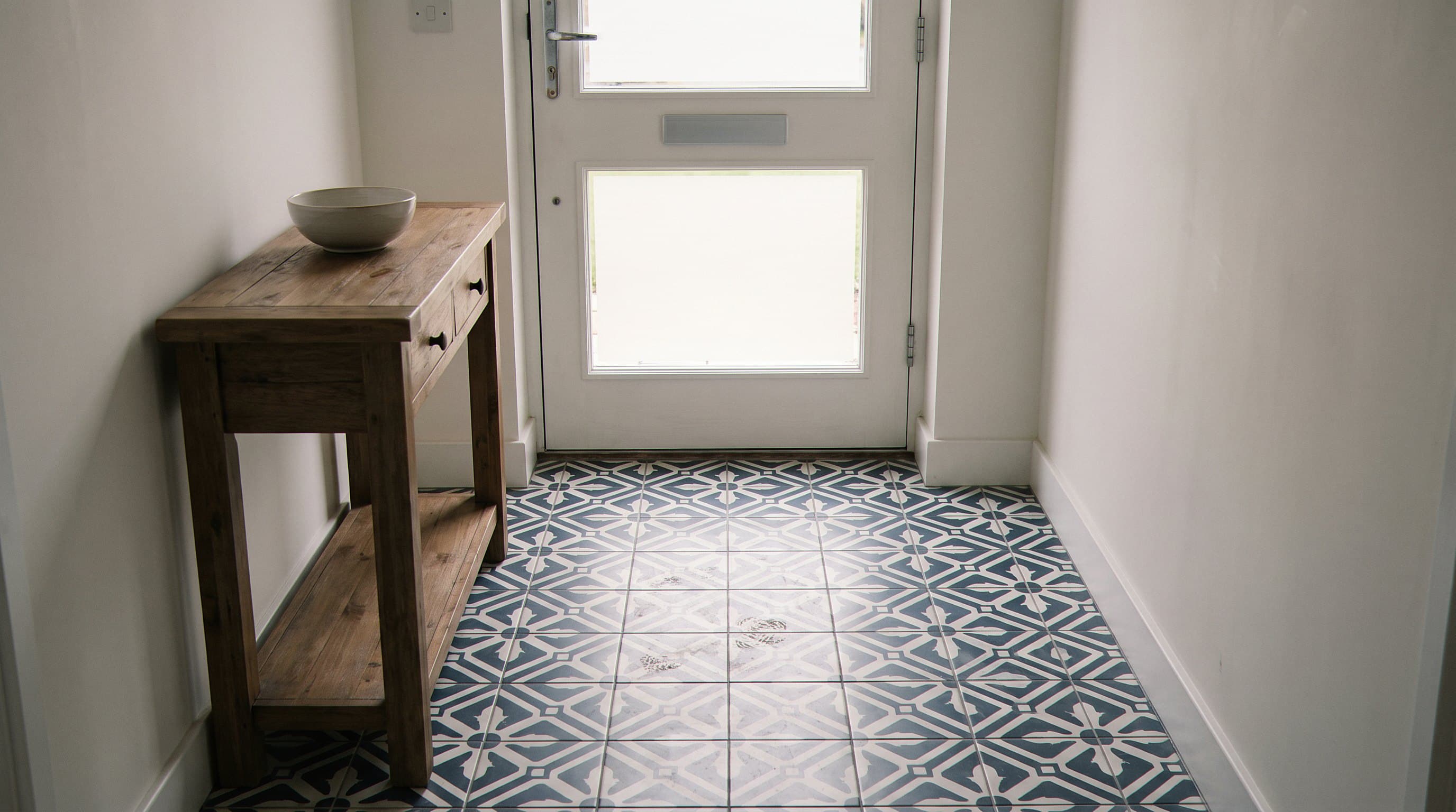 Floral medallion tile floor with muddy footprints in entryway