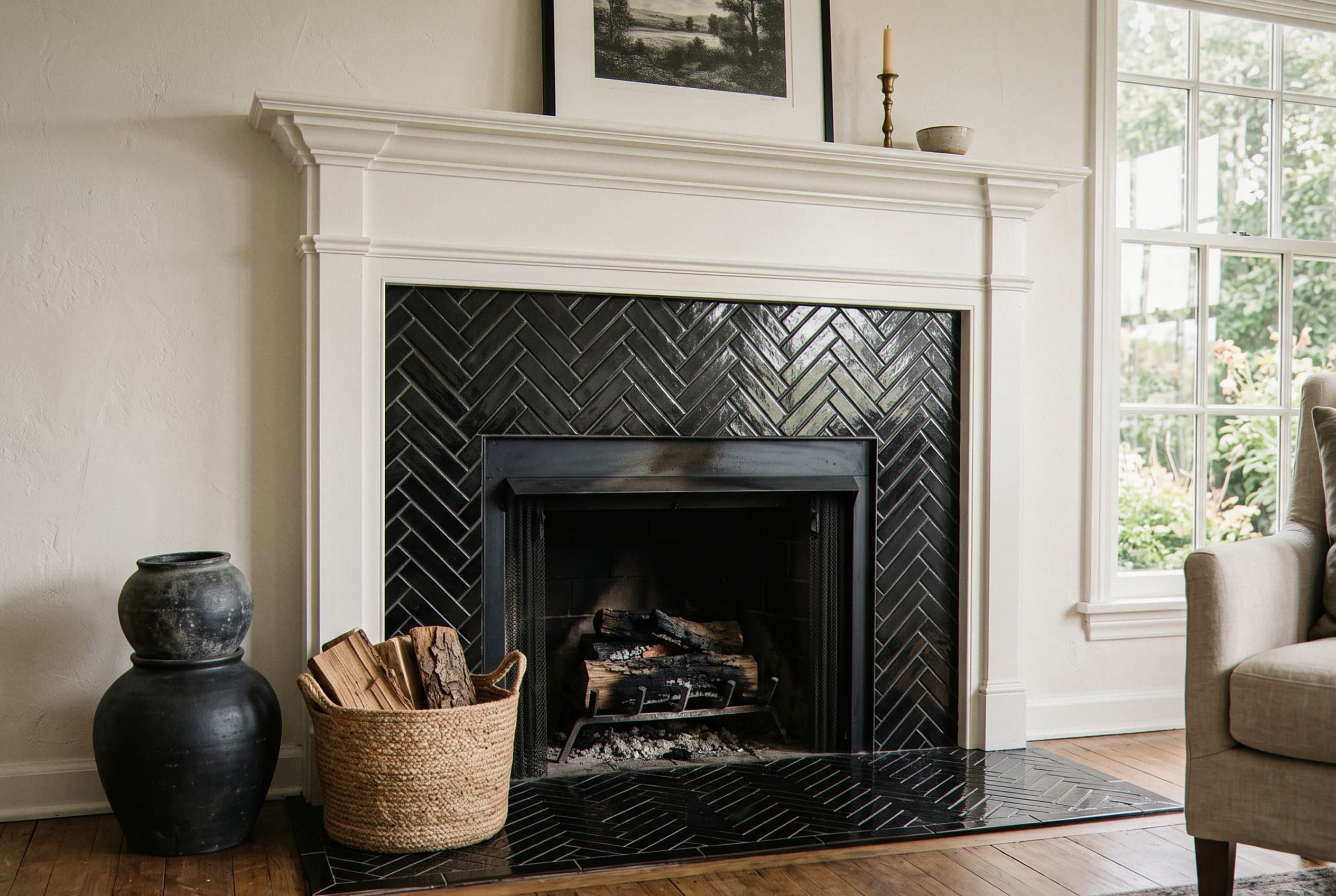 Black herringbone tile surround around a fireplace opening