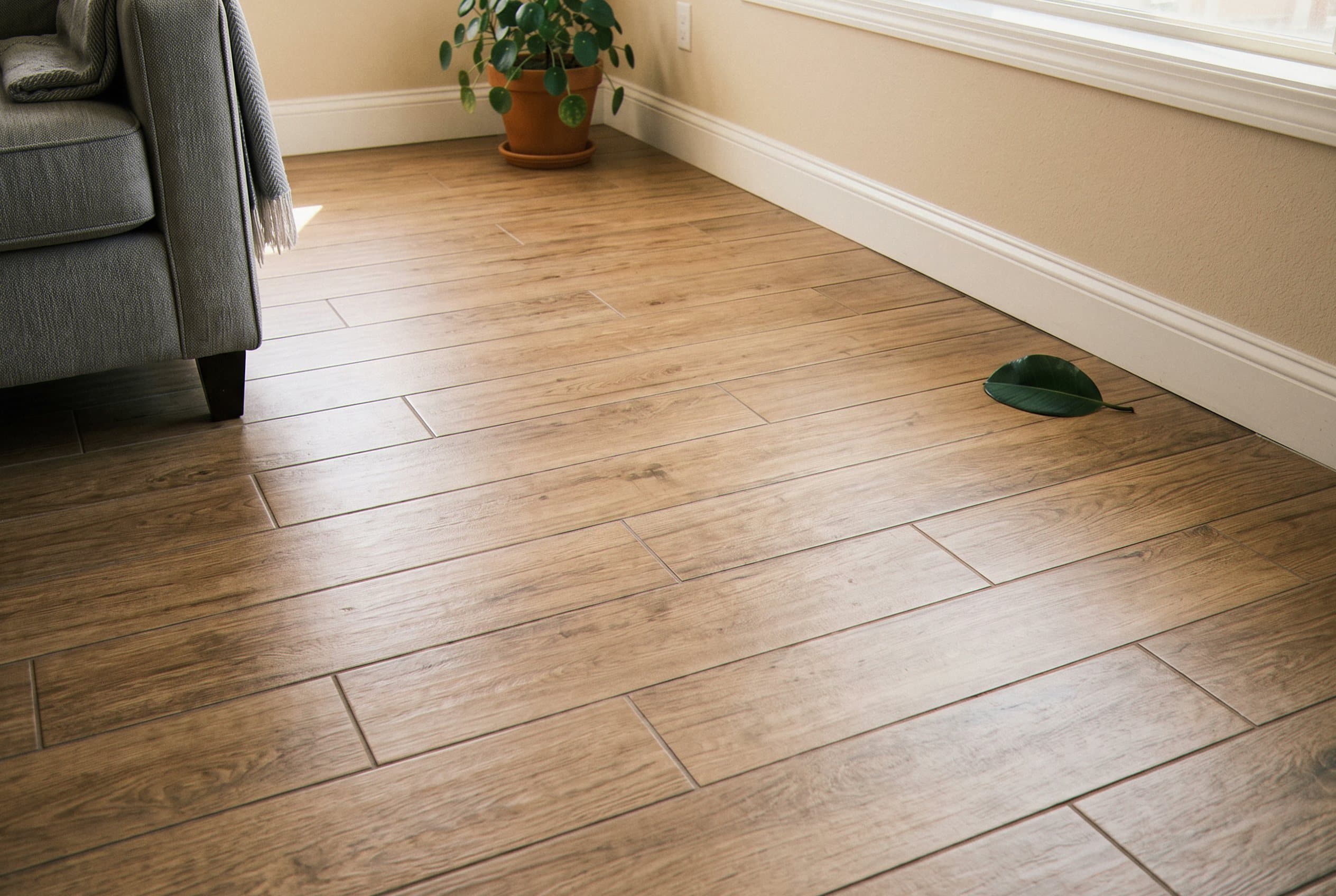 Wood-grain tile planks next to a gray sofa