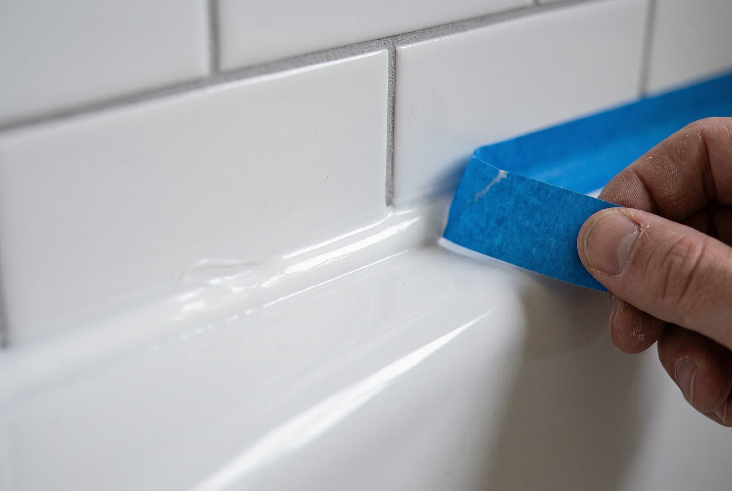 Taping off a fresh caulk line at the tub