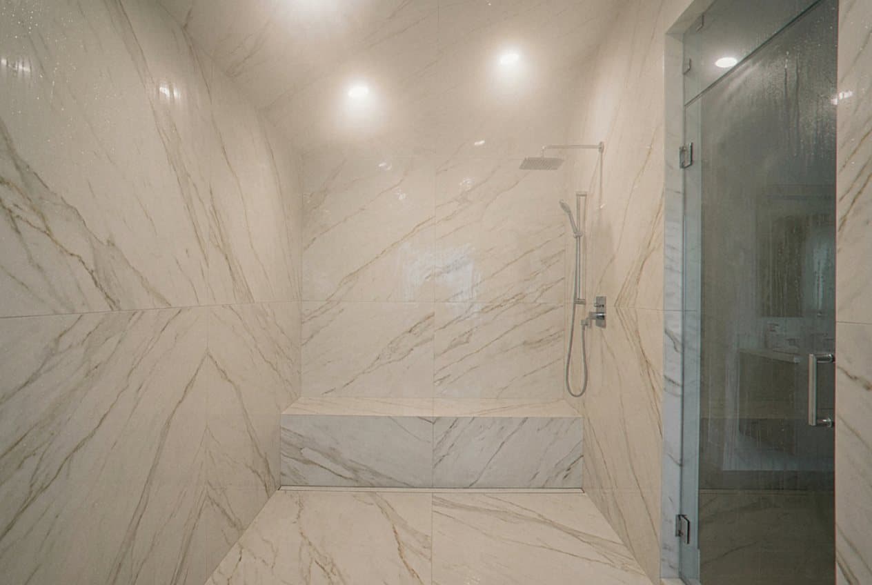 Marble steam shower with integrated bench and rain head